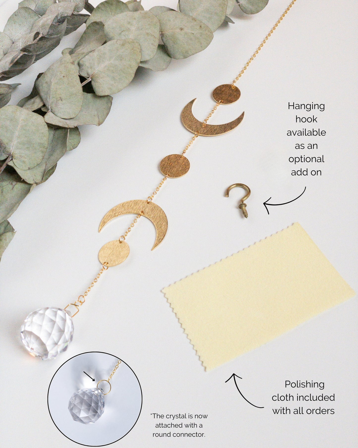 Brass and crystal suncatcher that disperses rainbow flecks around the walls and floor. A yellow metal polishing cloth which is included is shown. Also shown is a small brass hook which can be used to hang the sun catcher.